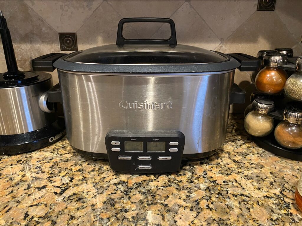 image shows Cuisinart slow cooker on kitchen counter next to food processor and spice rack