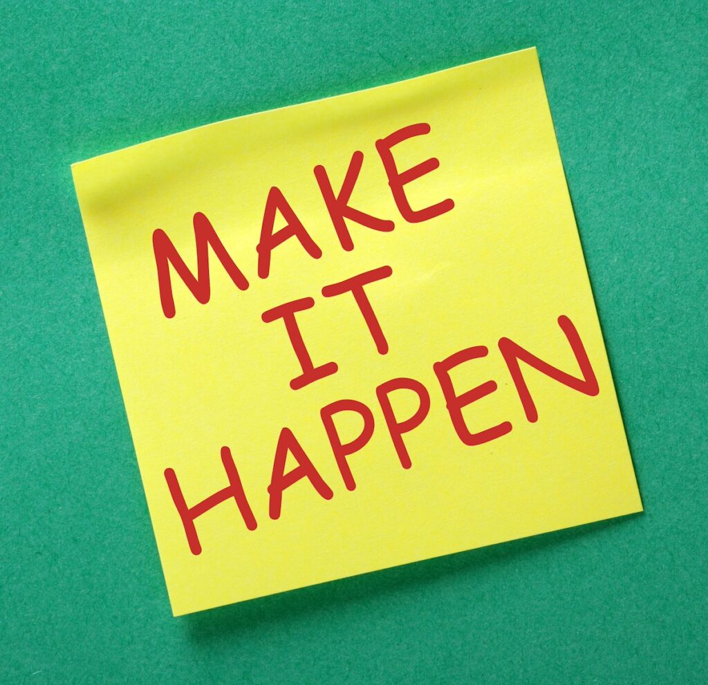 make it happen written in red ink on yellow paper with green background...quote to provide motivation to find calm in the chaos