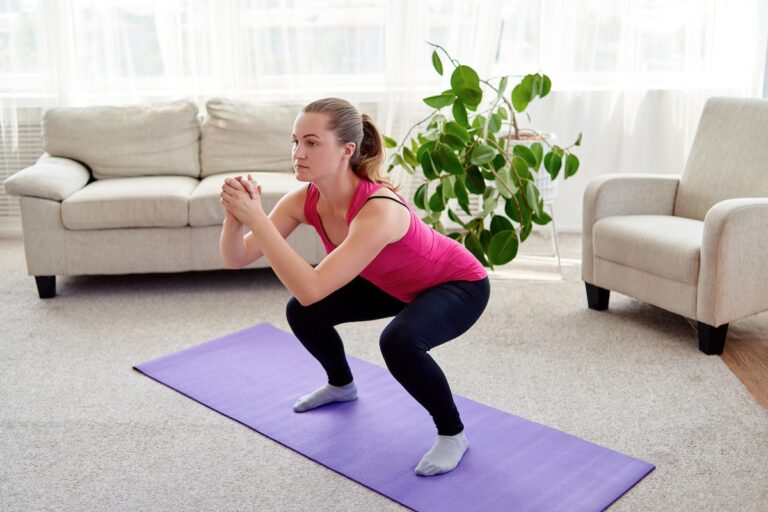 image shows woman doing squats in living room, following a 10-minute workouts for moms bodyweight circuit