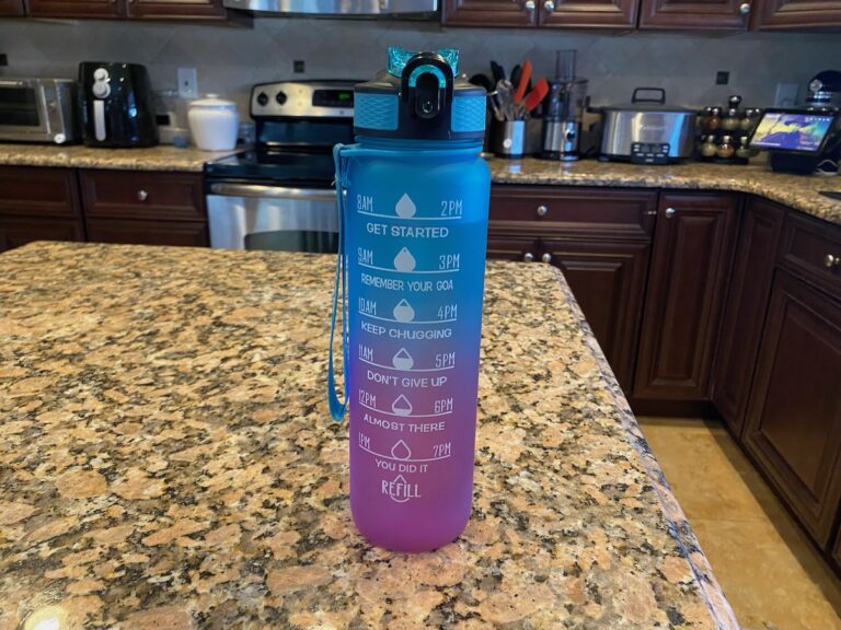 image shows blue and purple motivational water bottle with time marker on kitchen island