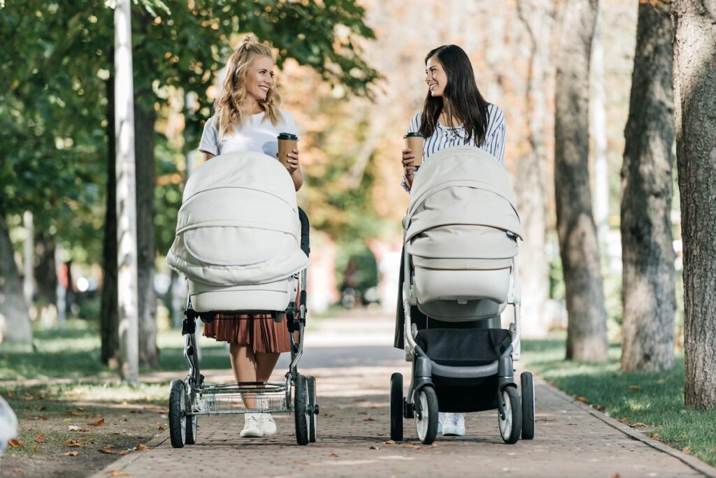image shows two women walking outside with strollers for exercise as self-care