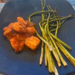 cooked slow cooker Italian chicken meal with roasted asparagus on dinner plate