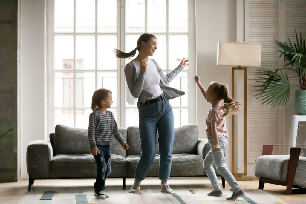 image shows mother dancing with daughter and son in living room, one of the low-impact workouts for moms