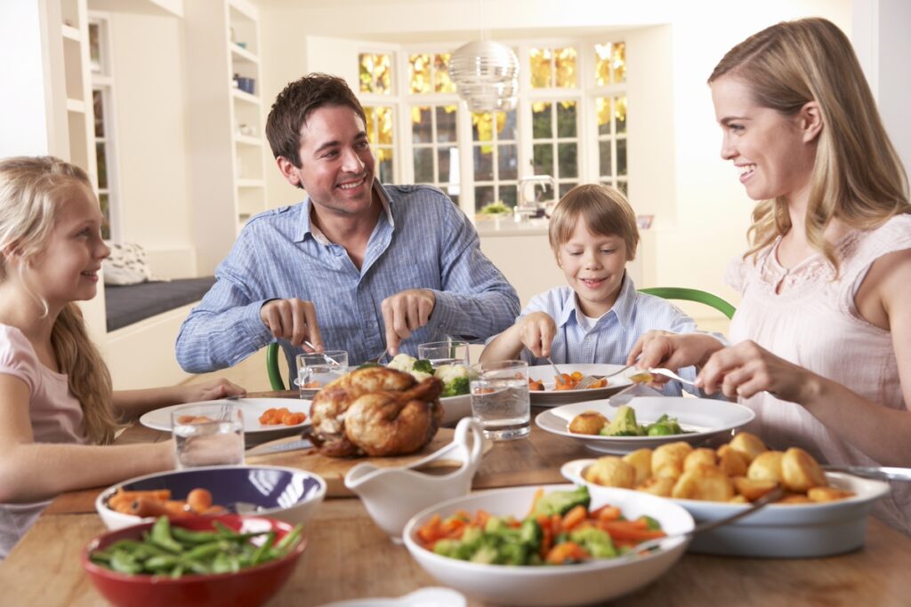 mother enjoying family dinner with husband and two children