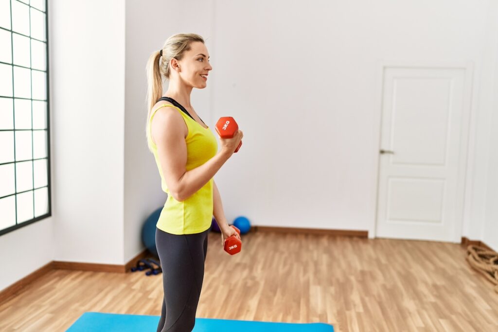 Mom doing dumbbell strength exercises at home, illustrating strength training for busy moms.