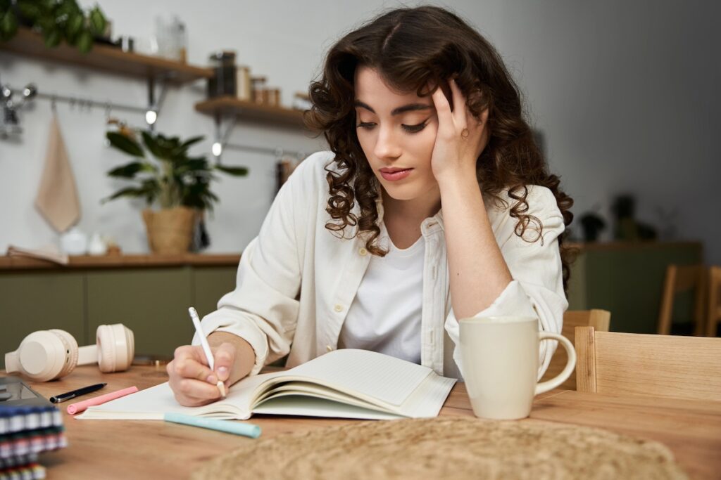 woman journaling to reflect on health goals without guilt