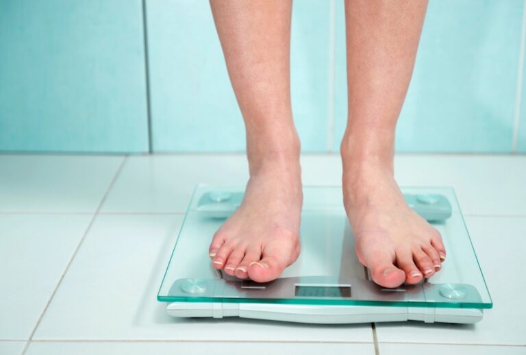 woman stepping off bathroom scale focusing on non-scale victories instead
