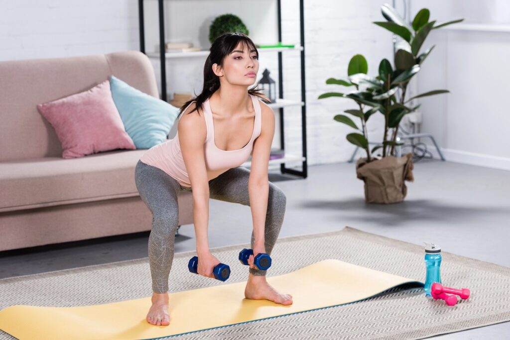 Woman demonstrating proper strength training form with dumbbells