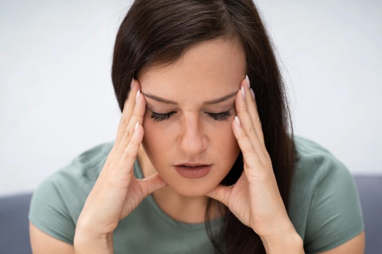 woman holding her head who is drained by hormones and energy levels