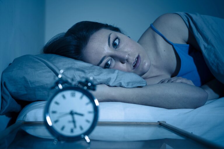 Woman feeling wired but tired sitting on couch in the evening