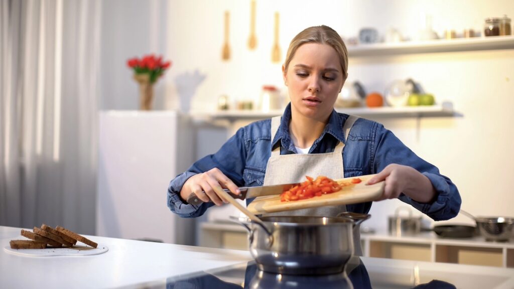 Mom feeling tense and overwhelmed while cooking dinner